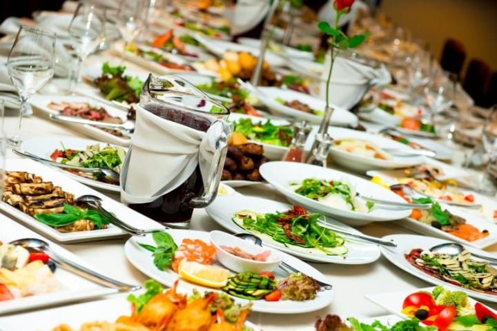 Table with white plates and a variety of food