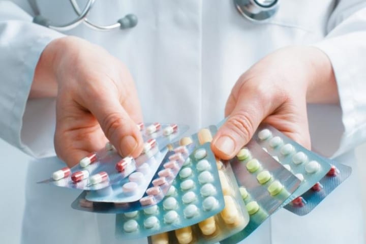 A doctor holding various colored pills